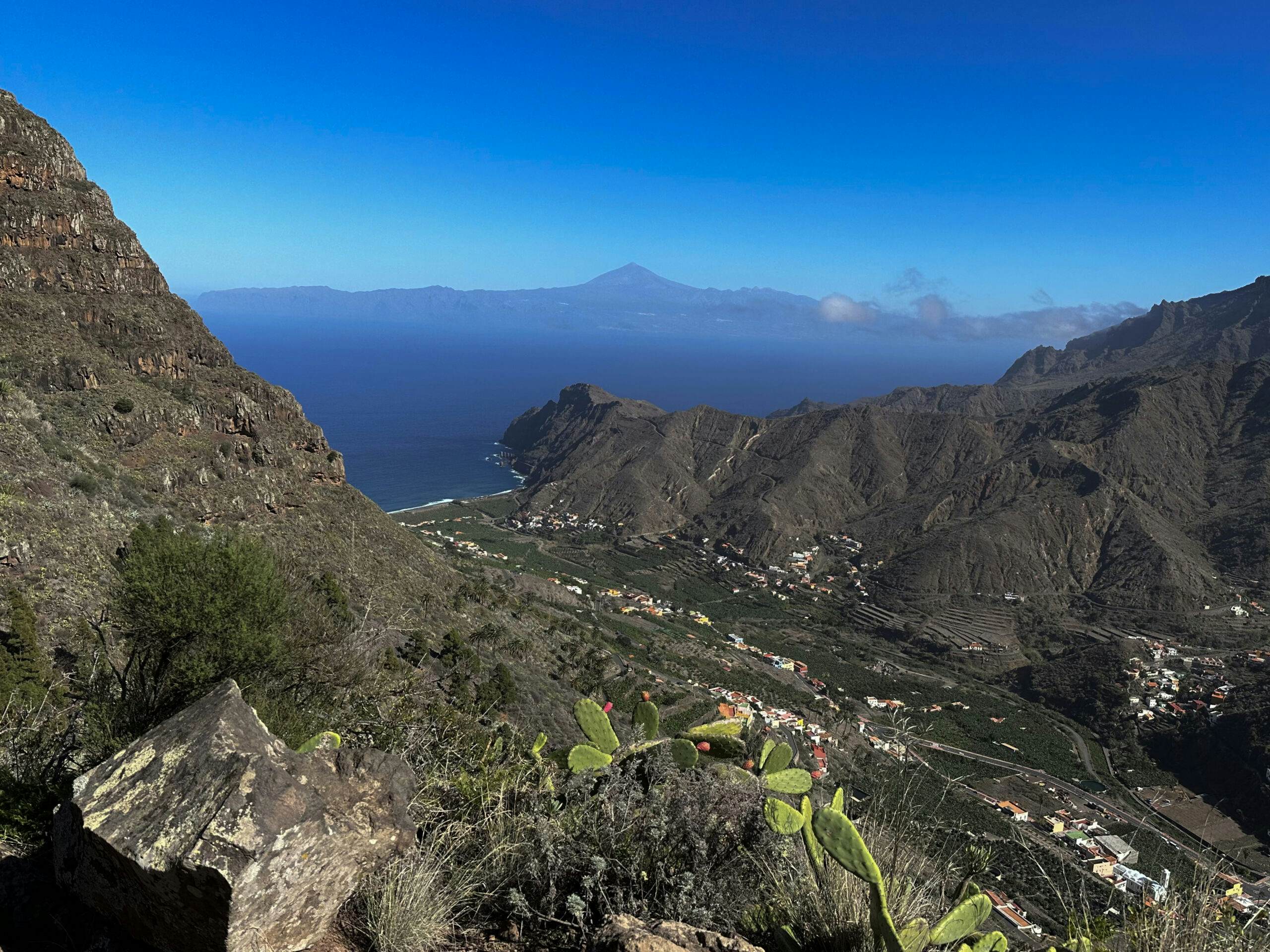 Blick vom Abstiegsweg auf Hermigua und Teneriffa mit Teide im Hintergrund